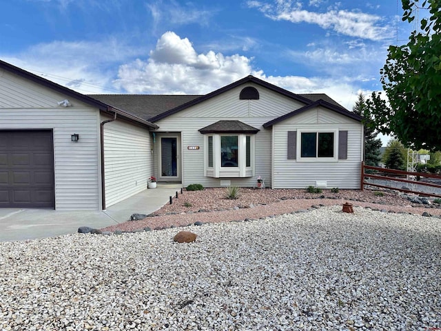 single story home with an attached garage, roof with shingles, and fence