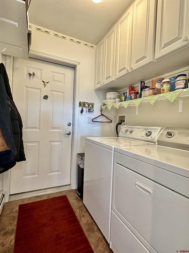 laundry area with a textured ceiling, cabinet space, and washing machine and clothes dryer