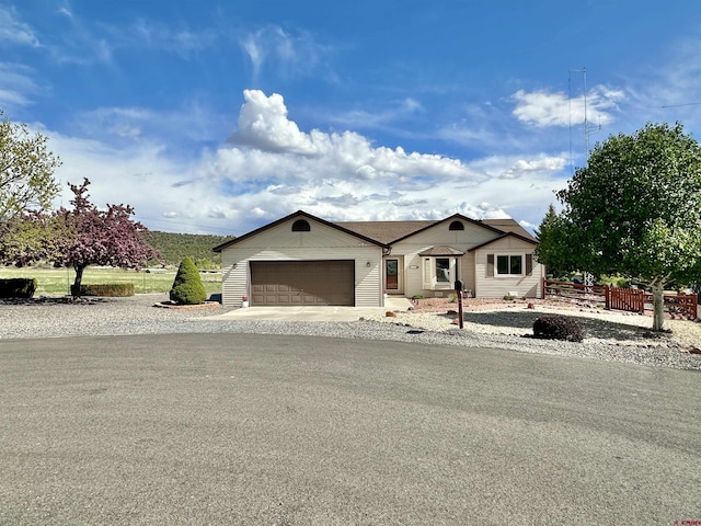 view of front of property with a garage, fence, and driveway