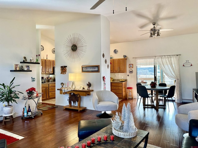 living room with a baseboard heating unit, ceiling fan, wood finished floors, and vaulted ceiling