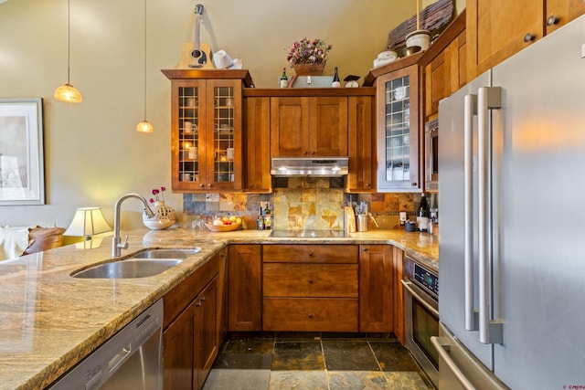 kitchen featuring backsplash, stainless steel appliances, brown cabinetry, and a sink