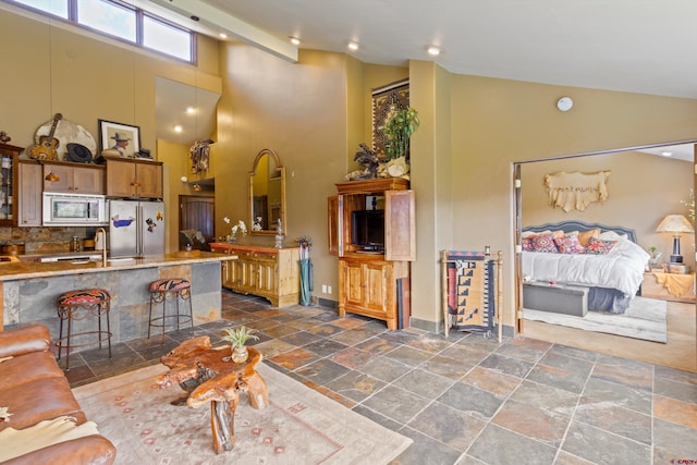 living area featuring high vaulted ceiling, baseboards, recessed lighting, and stone tile floors