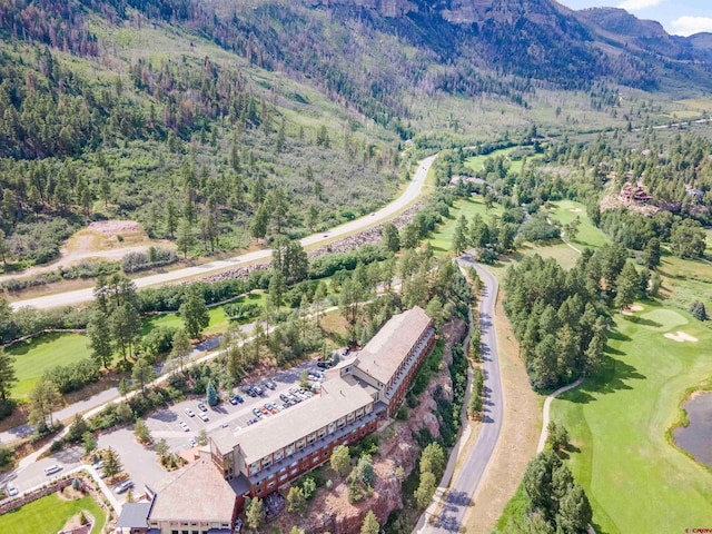 drone / aerial view featuring a view of trees, a mountain view, and view of golf course