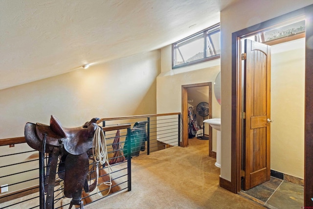 interior space featuring baseboards, carpet, and an upstairs landing