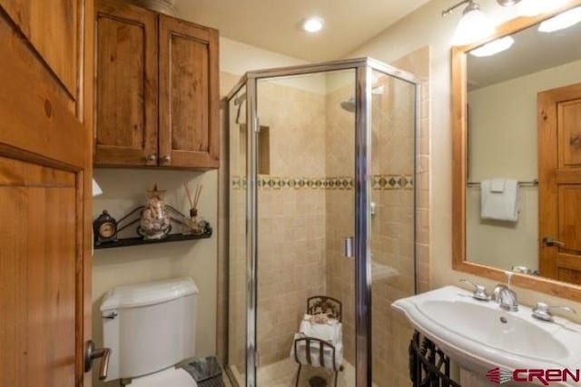 full bath with toilet, recessed lighting, a shower stall, and a sink