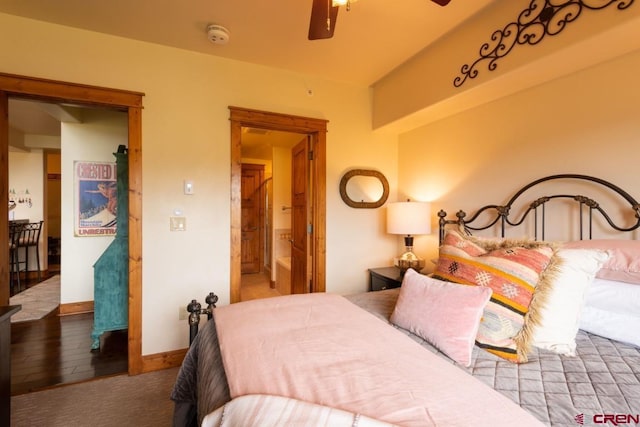 bedroom with wood-type flooring, connected bathroom, and baseboards