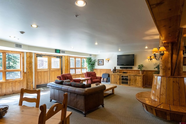 living area with visible vents, wainscoting, wood walls, light carpet, and recessed lighting