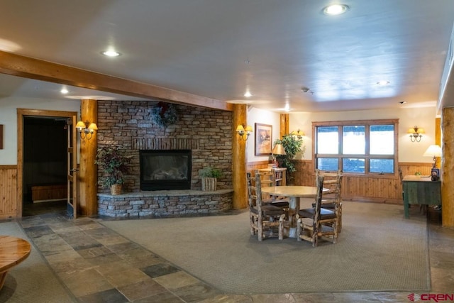 dining area with recessed lighting, wood walls, wainscoting, and a fireplace