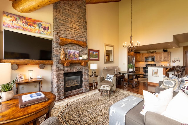 living area featuring high vaulted ceiling, a fireplace, wood finished floors, and a notable chandelier