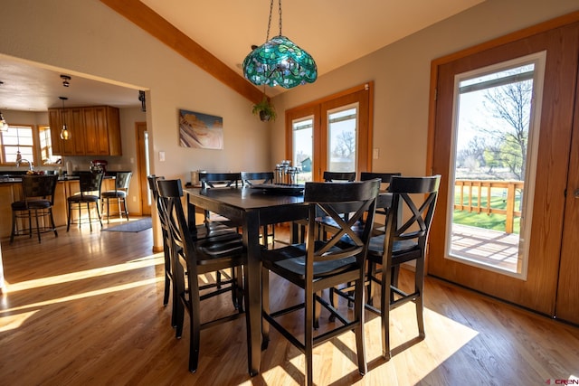 dining area featuring lofted ceiling and light wood-type flooring