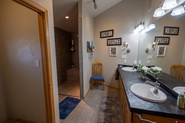 full bath featuring a walk in shower, tile patterned floors, vaulted ceiling, and a sink