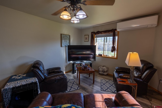living area featuring baseboards, a ceiling fan, a wall unit AC, and wood finished floors