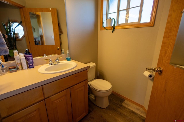 bathroom with vanity, wood finished floors, and toilet