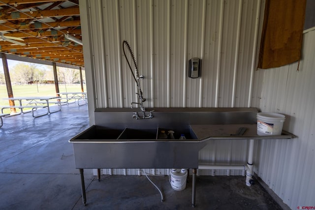 miscellaneous room with a sink and unfinished concrete floors