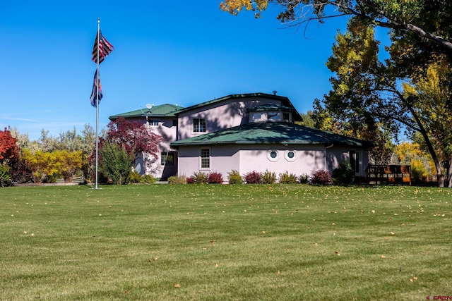 view of side of home with a lawn and stucco siding