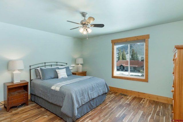 bedroom with baseboards, a ceiling fan, and wood finished floors