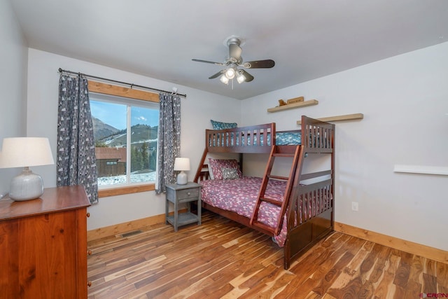 bedroom with baseboards, wood finished floors, and visible vents