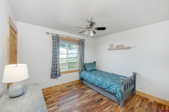 bedroom featuring baseboards, a ceiling fan, and wood finished floors