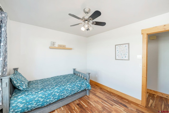 bedroom with baseboards, a ceiling fan, and wood finished floors
