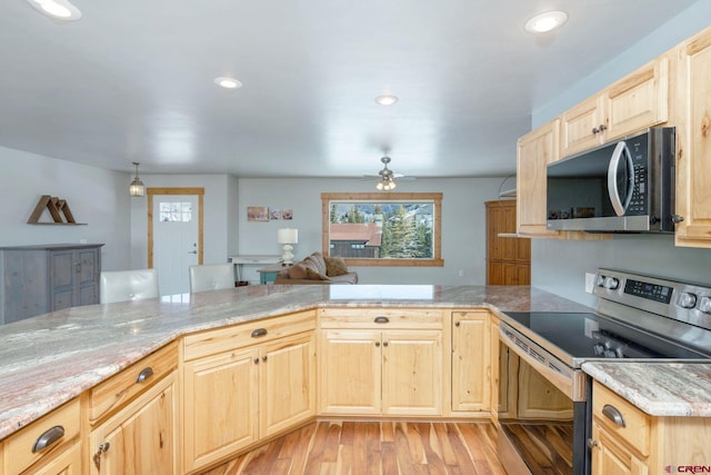 kitchen featuring appliances with stainless steel finishes, light wood-style floors, light brown cabinets, a ceiling fan, and a peninsula