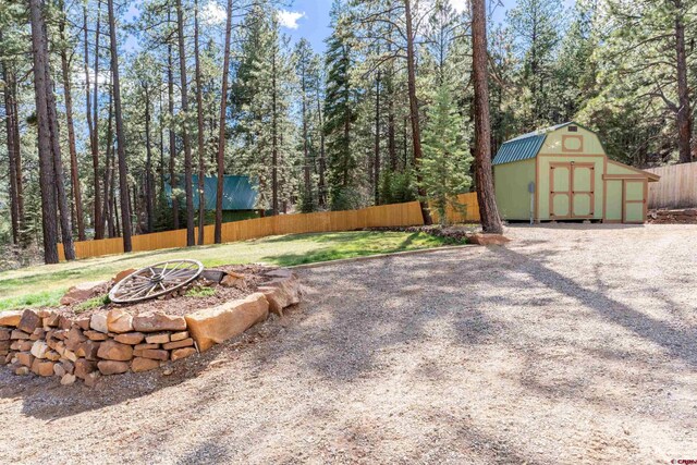561 Sierra Dr, Durango, CO 81301 - view of yard with a storage shed, an outdoor structure, a fenced backyard, and an outdoor fire pit