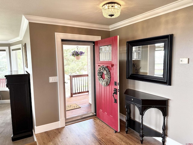 22876 Thunder Mountain Ln, Cedaredge, CO 81413 - foyer featuring baseboards, an inviting chandelier, ornamental molding, and wood finished floors