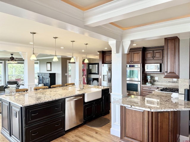 22876 Thunder Mountain Ln, Cedaredge, CO 81413 - kitchen with a sink, light wood-style floors, stainless steel appliances, open floor plan, and decorative backsplash