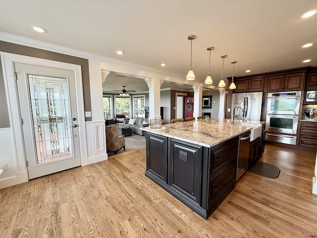 22876 Thunder Mountain Ln, Cedaredge, CO 81413 - kitchen with ceiling fan, ornate columns, a sink, appliances with stainless steel finishes, and a warming drawer