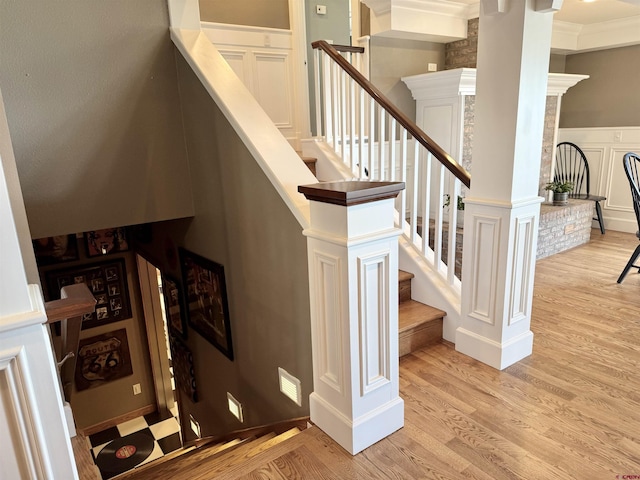 22876 Thunder Mountain Ln, Cedaredge, CO 81413 - staircase with wainscoting, a decorative wall, and wood finished floors