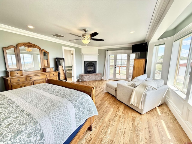 22876 Thunder Mountain Ln, Cedaredge, CO 81413 - bedroom with visible vents, crown molding, a fireplace, access to exterior, and light wood-type flooring