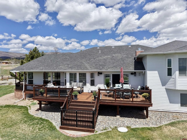 22876 Thunder Mountain Ln, Cedaredge, CO 81413 - rear view of house featuring a deck, a shingled roof, and outdoor dining area
