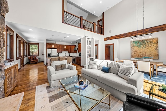 living area featuring recessed lighting, a high ceiling, and light wood-style floors