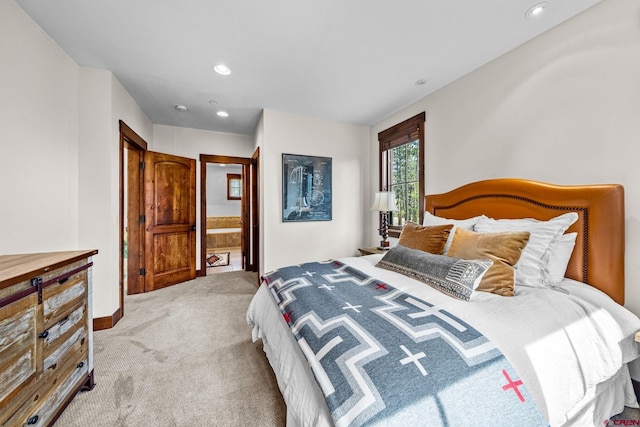 carpeted bedroom featuring baseboards, recessed lighting, and ensuite bath
