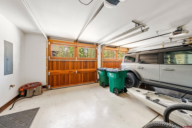 garage featuring baseboards, a garage door opener, and electric panel