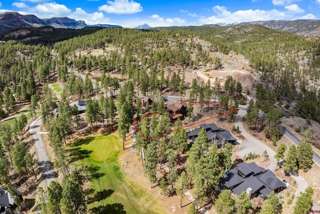 aerial view featuring a mountain view, golf course view, and a forest view
