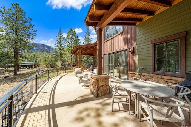 view of patio / terrace featuring a mountain view and outdoor dining space