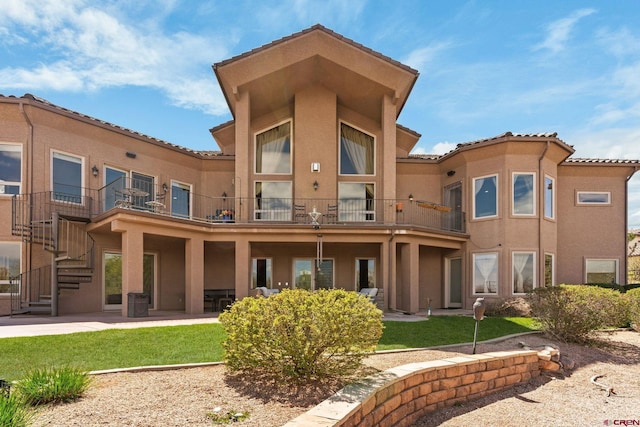 714 Washington Ct, Grand Junction, CO 81507 - rear view of property featuring stucco siding, a balcony, a lawn, a tile roof, and a patio area