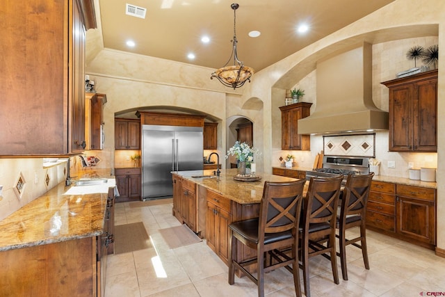 714 Washington Ct, Grand Junction, CO 81507 - kitchen featuring stainless steel appliances, custom range hood, a sink, a center island with sink, and light tile patterned floors