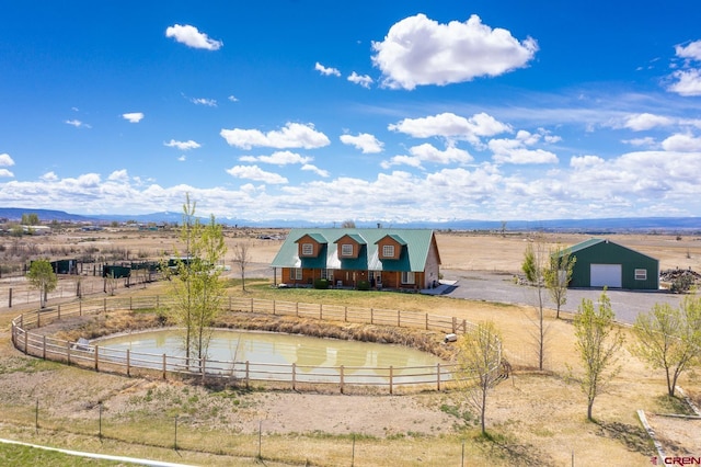 property view of water featuring a rural view, fence, and a mountain view