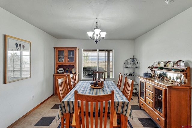 dining area featuring light tile patterned floors, baseboards, and a notable chandelier