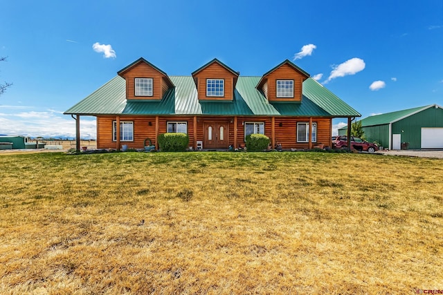 view of front of home featuring a garage, an outdoor structure, and a front lawn