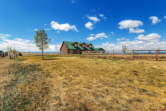 view of yard with fence and a rural view