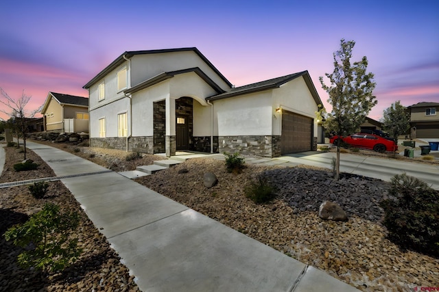 589 Treviso Ct, Grand Junction, CO 81501 - view of front of house with a garage, stucco siding, concrete driveway, and stone siding
