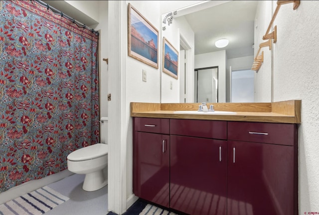 full bath featuring toilet, a textured wall, a shower with shower curtain, and vanity