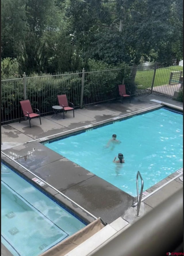 view of swimming pool with fence, a fenced in pool, and a patio