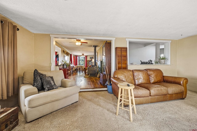 living area featuring a ceiling fan, carpet flooring, and a textured ceiling
