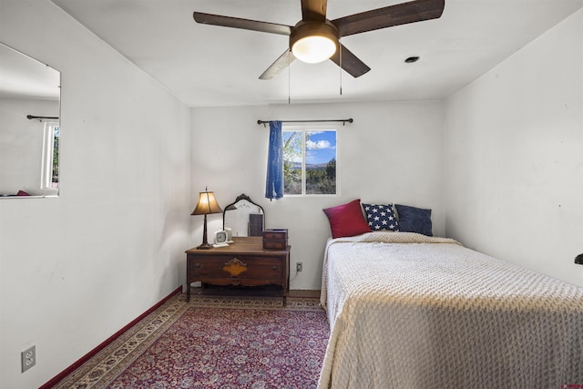 carpeted bedroom featuring baseboards and a ceiling fan