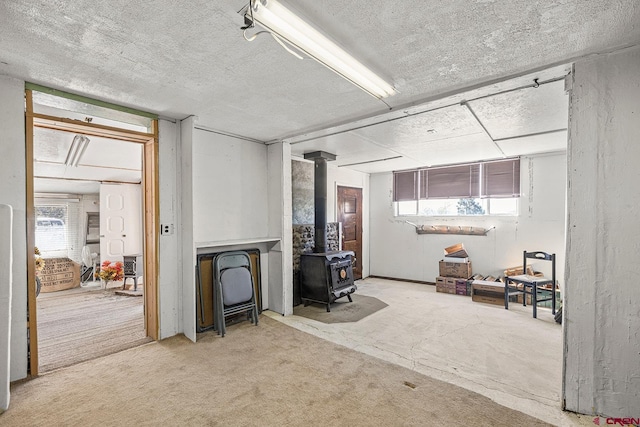 interior space with a wood stove and a textured ceiling
