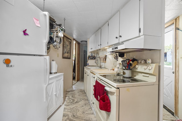 kitchen featuring a sink, light countertops, under cabinet range hood, white appliances, and white cabinetry
