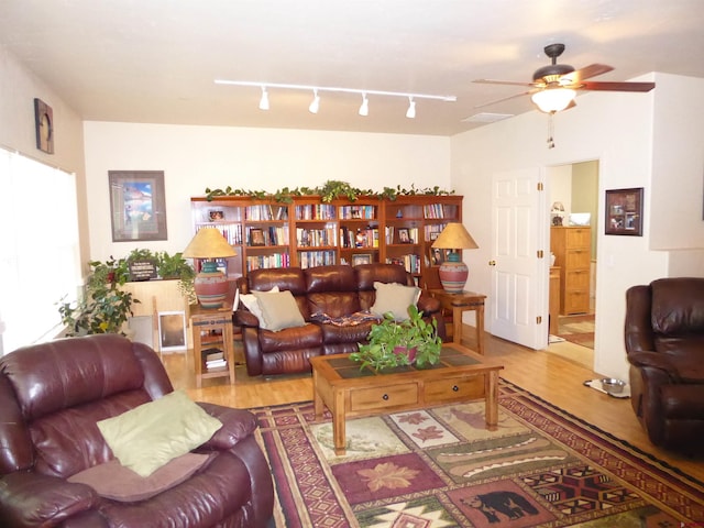 living room with wood finished floors and a ceiling fan